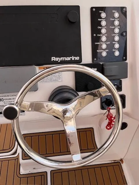 Slide: The Image of Century 24 Resorter 2020 boat dashboard with steering wheel and Raymarine controls. - 9
