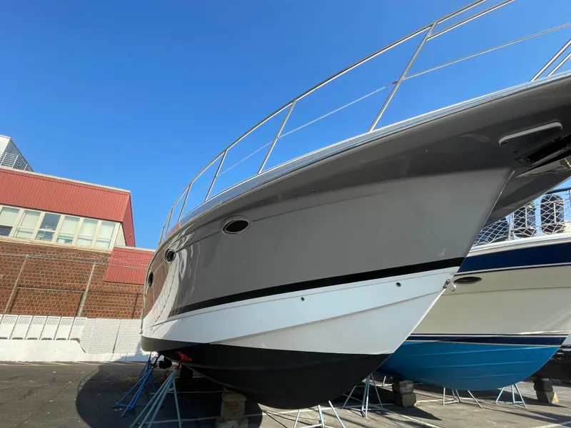 Slide: The Image of 2014 Formula 45 Yacht on stands, sleek design, gray hull, clear blue sky background. - 9