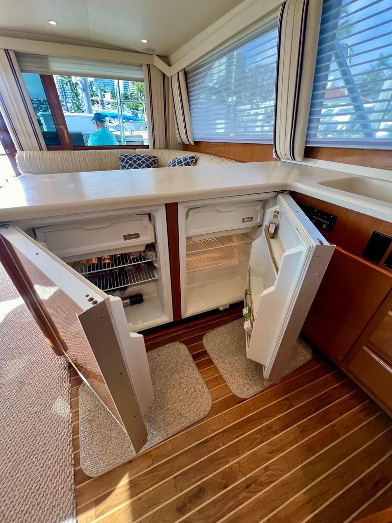 Slide: The Image of 1999 Viking Conv Sport Fisher interior with open fridge, wooden flooring, and large windows. - 10
