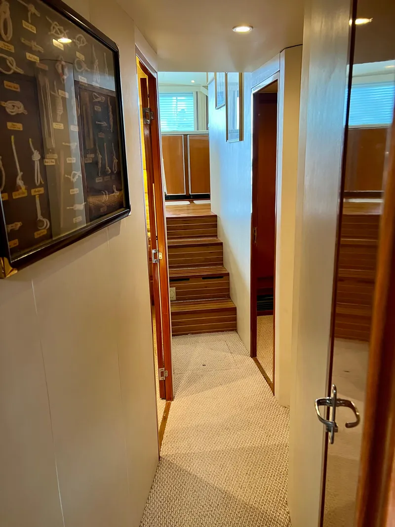 Slide: The Image of Interior hallway of 1999 Viking Conv Sport Fisher yacht with wooden steps and framed artwork. - 14