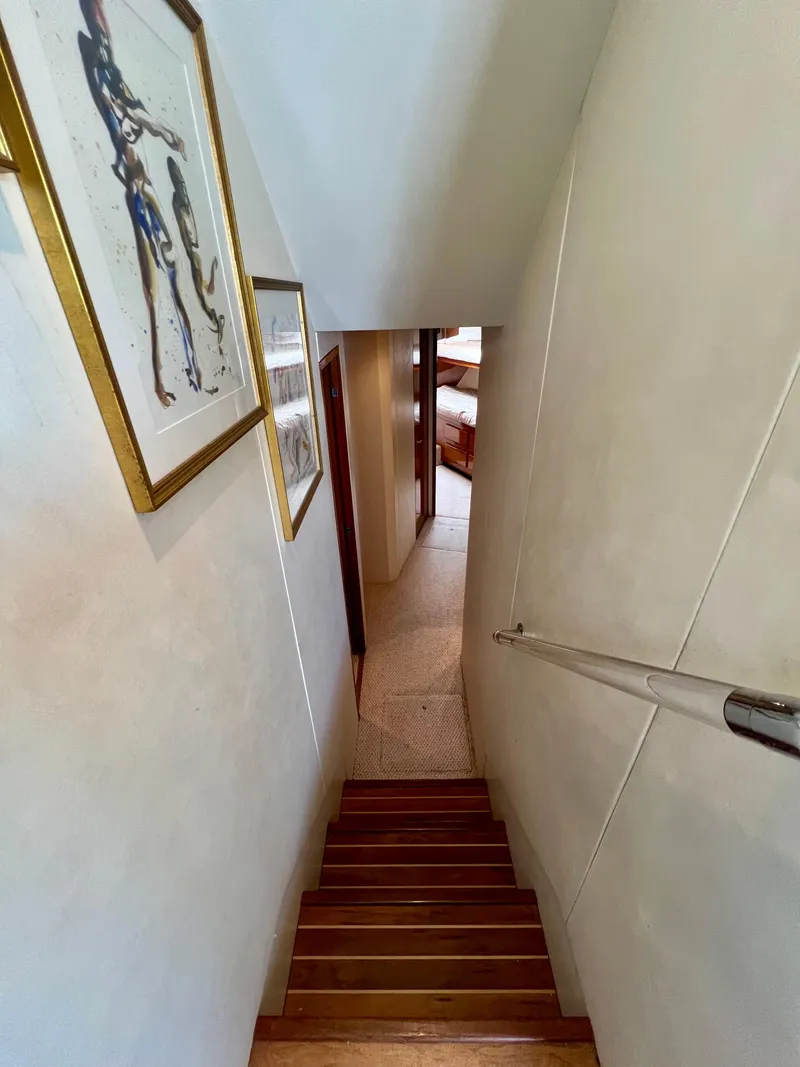 Slide: The Image of Interior staircase of 1999 Viking Conv Sport Fisher yacht with artwork on walls. - 17