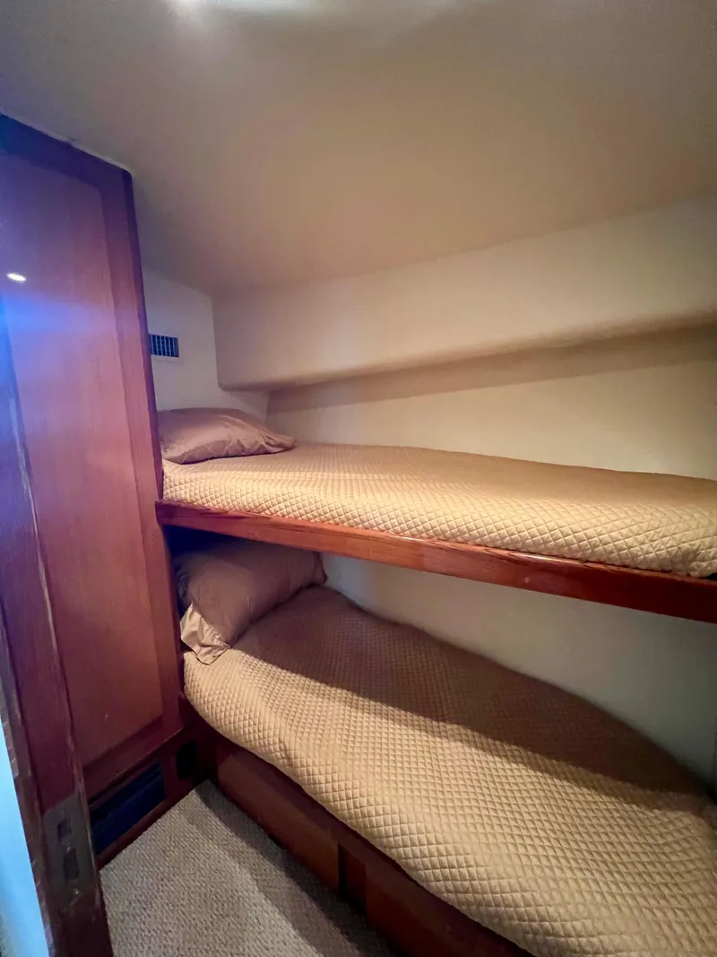 Slide: The Image of 1999 Viking Conv Sport Fisher cabin with cozy twin bunk beds and wooden accents. - 21