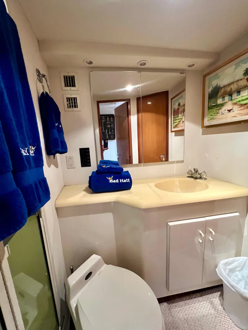 Slide: The Image of Bathroom interior of 1999 Viking Conv Sport Fisher yacht with sink, mirror, and blue towels. - 22