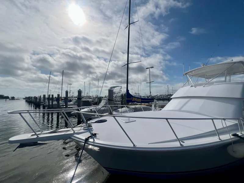 Slide: The Image of 1999 Viking Conv Sport Fisher yacht docked at marina under cloudy sky. - 3