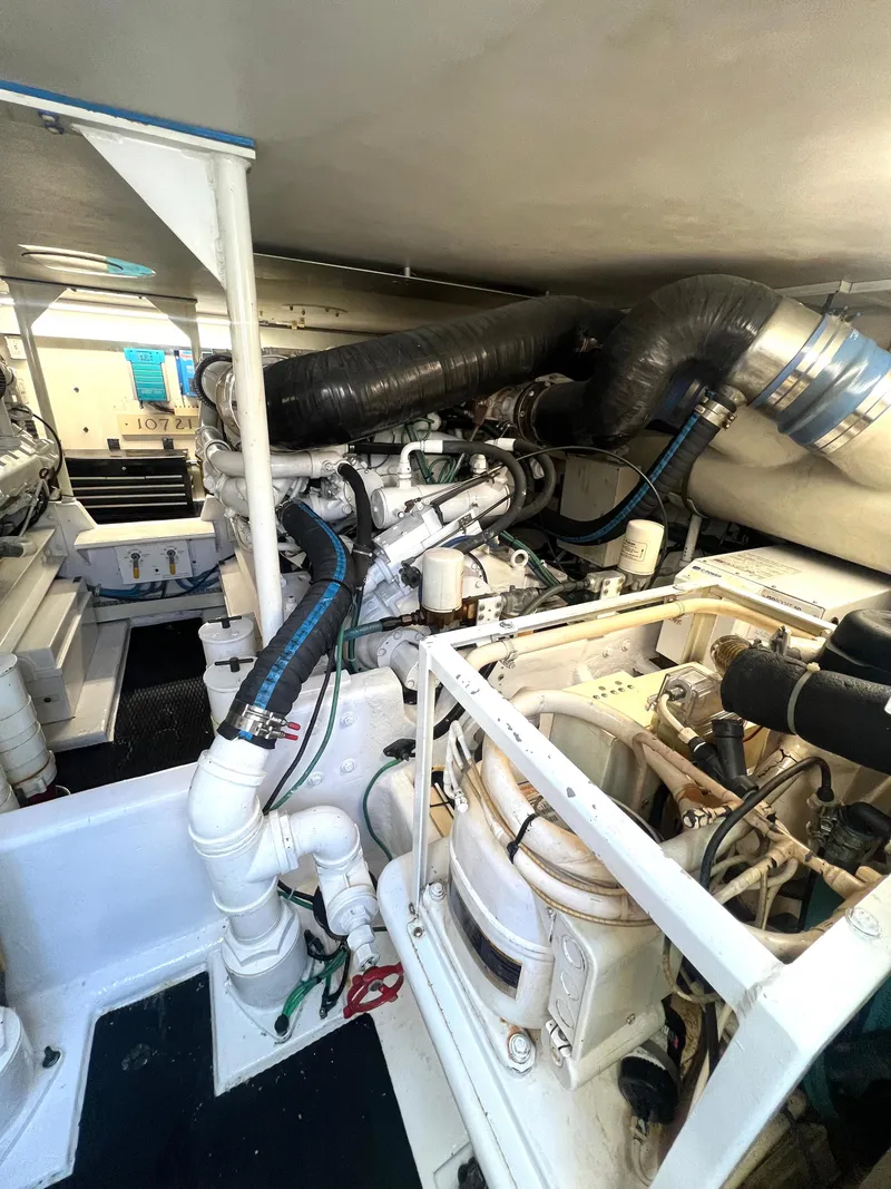 Slide: The Image of Engine room of 1999 Viking Conv Sport Fisher boat, showcasing machinery and piping. - 34