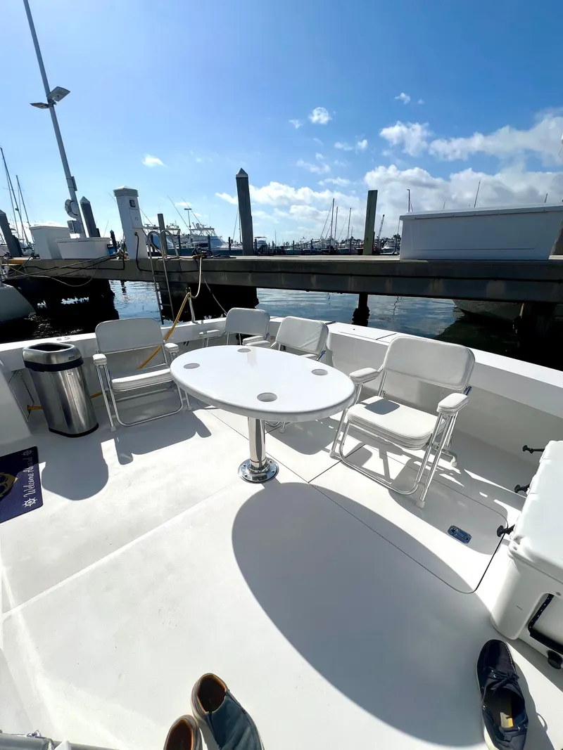 Slide: The Image of 1999 Viking Conv Sport Fisher boat deck with chairs and table at marina. - 36