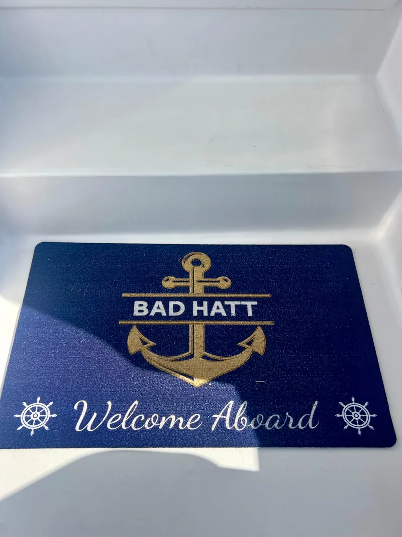Slide: The Image of Welcome mat on 1999 Viking Conv Sport Fisher boat, featuring anchor design and "Bad Hatt" text. - 37