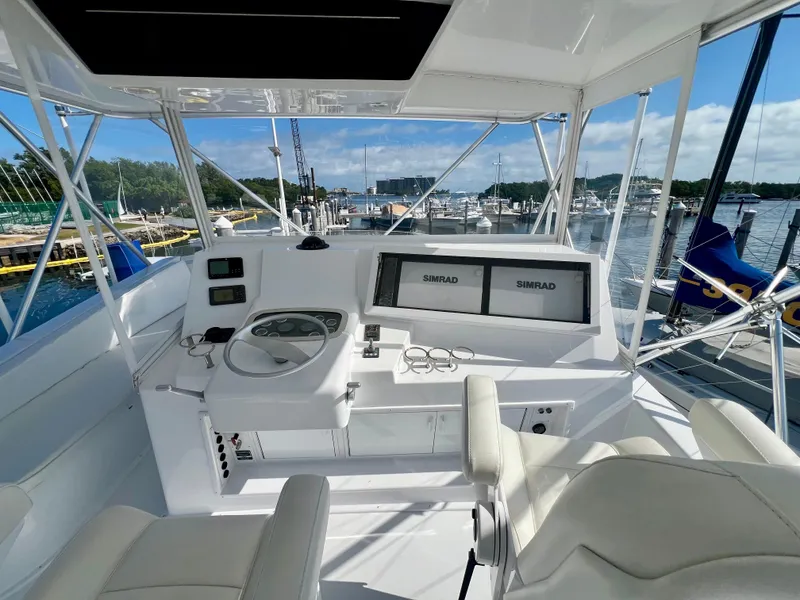 Slide: The Image of 1999 Viking Conv Sport Fisher helm with dual Simrad displays, docked at a marina. - 43