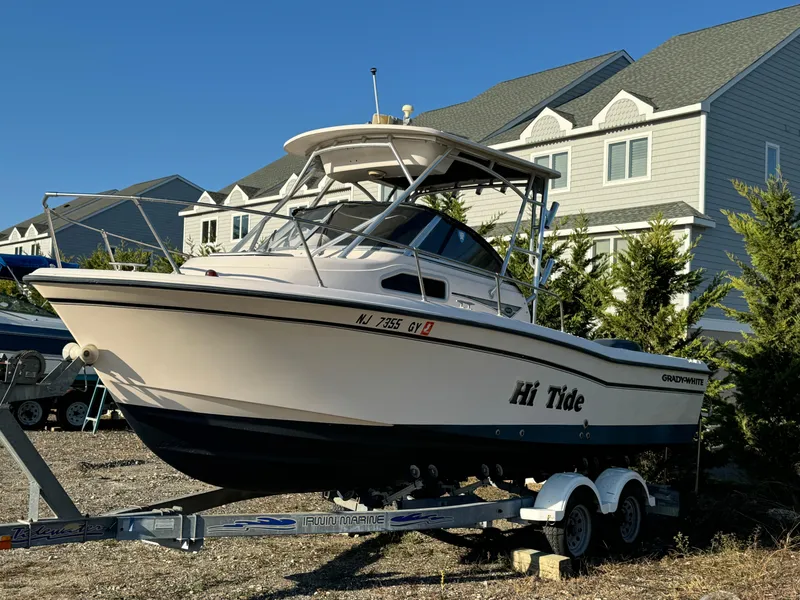 Slide: The Image of 2006 Grady-White Seafarer 226 boat on trailer, parked near houses. - 3