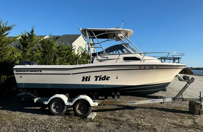 Slide: The Image of 2006 Grady-White Seafarer 226 boat on trailer, labeled "Hi Tide," parked near trees. - 4