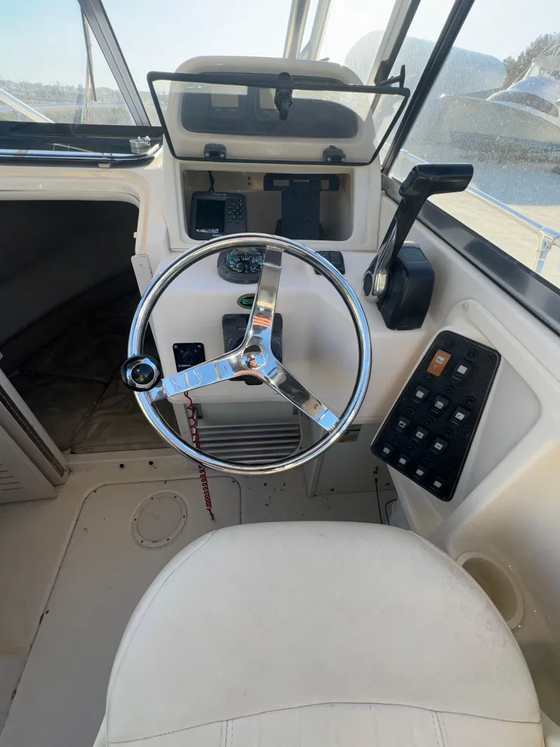 Slide: The Image of 2006 Grady-White Seafarer 226 boat helm with steering wheel and control panel. - 8