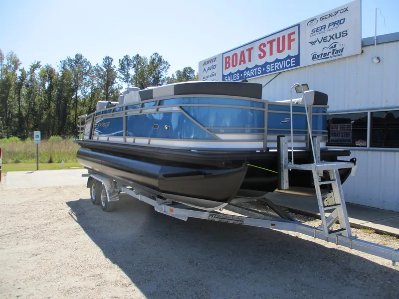 Slide: The Image of 2025 Starcraft CX 23 RL pontoon boat on trailer at dealership. - 1