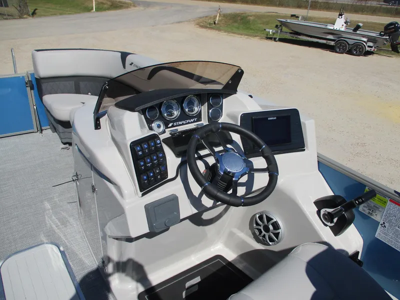Slide: The Image of 2025 Starcraft CX 23 RL boat dashboard with steering wheel and control panel. - 14