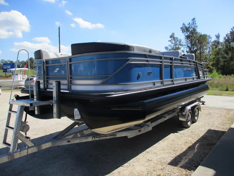 Slide: The Image of 2025 Starcraft CX 23 RL pontoon boat on trailer, blue and black design. - 3