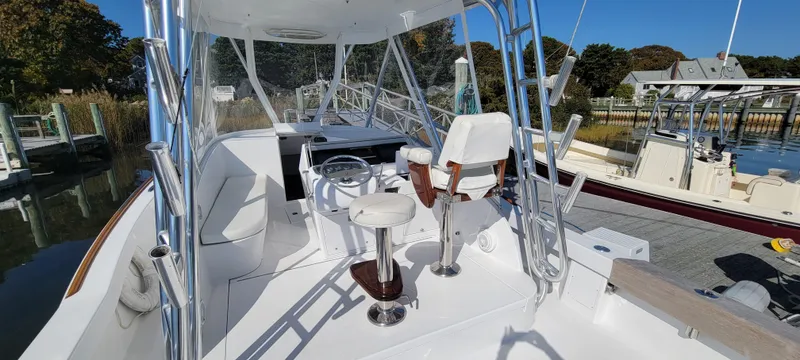 Slide: The Image of 2017 L&H 33 boat interior with helm, seating, and clear skies. - 10
