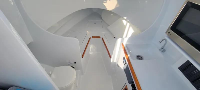 Slide: The Image of Interior of 2017 L&H 33 boat with sleek white design and compact amenities. - 23