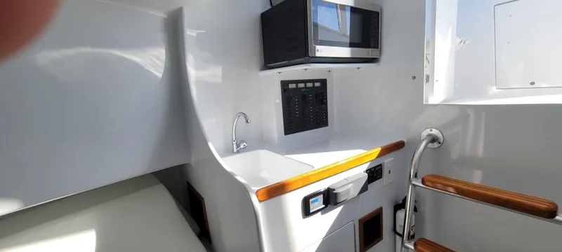 Slide: The Image of Compact boat interior with sink, microwave, and control panel in L&H 33, 2017 model. - 25