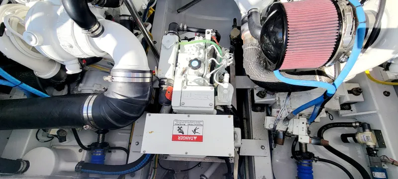Slide: The Image of Engine compartment of a 2017 L&H 33 boat, featuring various mechanical components and hoses. - 29