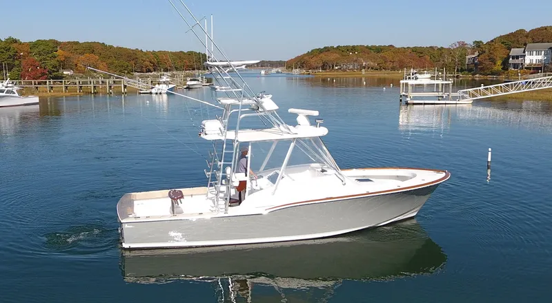 Slide: The Image of 2017 L&H 33 boat cruising on a serene lake with autumn foliage. - 5