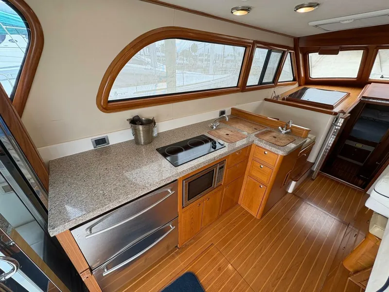 Slide: The Image of 2008 Rivolta Coupe 4.5 kitchen with granite countertops, stove, microwave, and wooden cabinetry. - 3