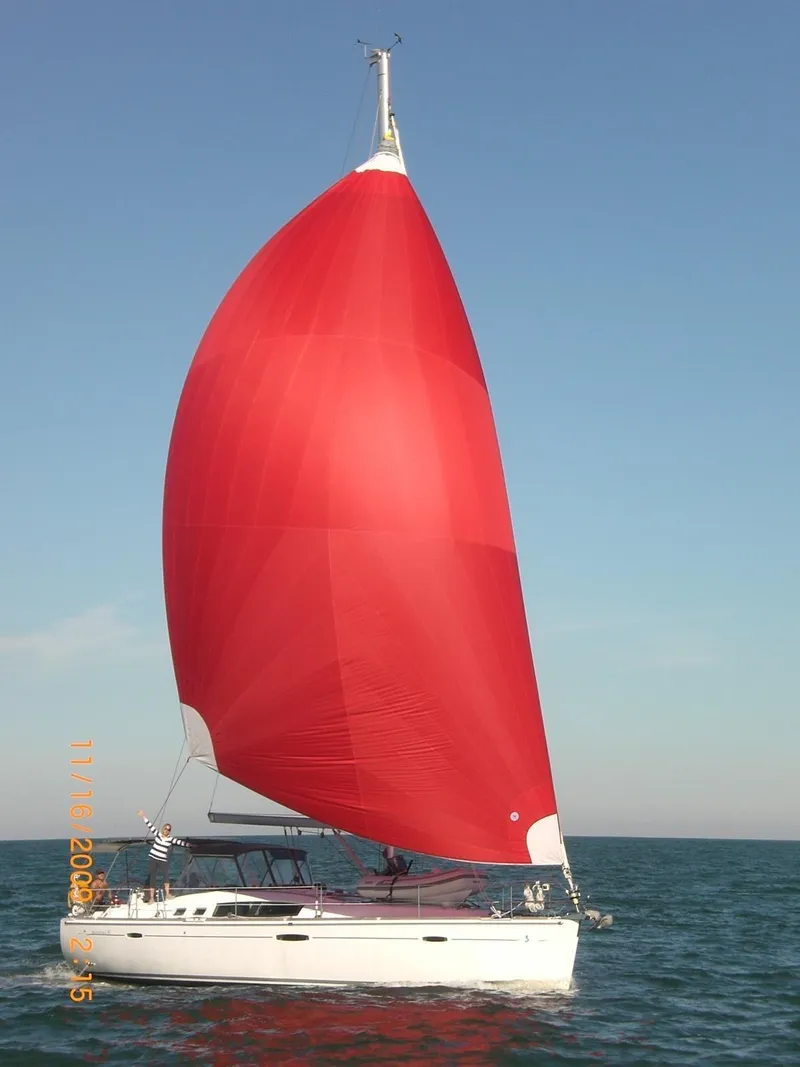 Slide: The Image of 2008 Beneteau Oceanis 46 sailing with a vibrant red spinnaker on open water. - 10