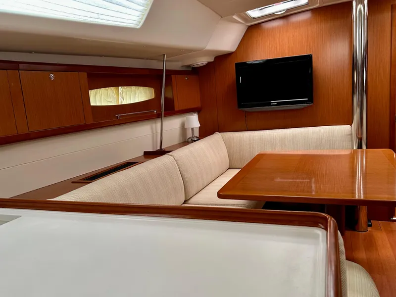 Slide: The Image of Interior of 2008 Beneteau Oceanis 46 yacht with cozy seating and wooden table. - 24