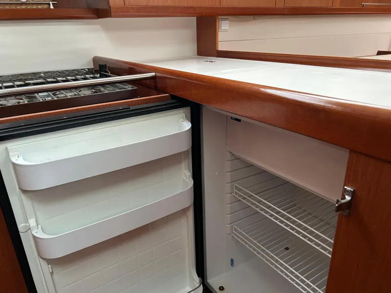 Slide: The Image of Kitchen area of 2008 Beneteau Oceanis 46 yacht with open fridge and wooden cabinetry. - 45