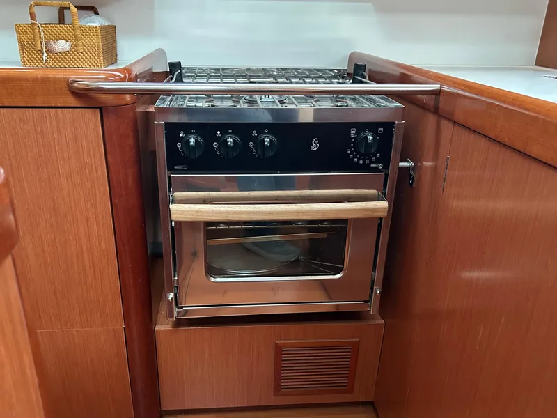 Slide: The Image of Beneteau Oceanis 46 (2008) yacht kitchen with stainless steel oven and wooden cabinetry. - 46