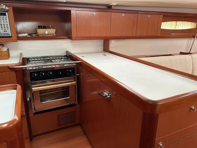 Slide: The Image of Interior of 2008 Beneteau Oceanis 46 yacht kitchen with wood cabinetry and stove. - 47