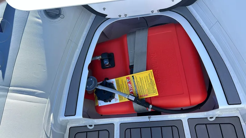 Slide: The Image of 2025 Highfield CL340 boat storage compartment with red gasoline tank and safety instructions. - 6