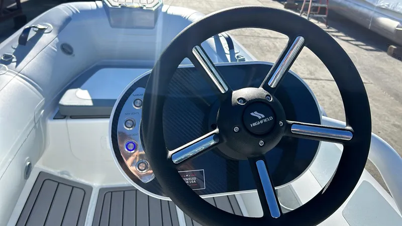 Slide: The Image of 2025 Highfield CL340 boat steering wheel and control panel in sunlight. - 7