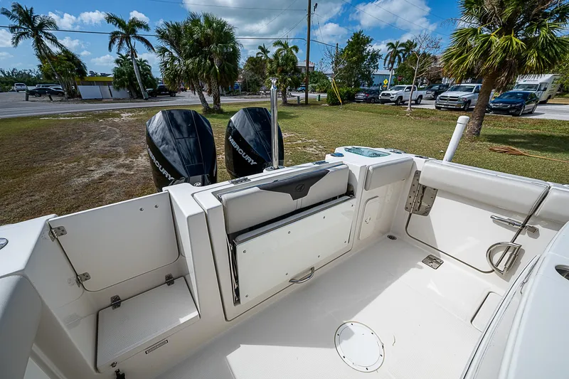 Slide: The Image of 2022 Sailfish 272CC boat interior with dual outboard motors, parked near palm trees. - 11