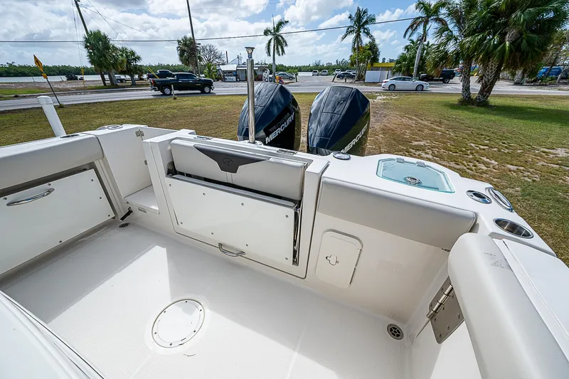 Slide: The Image of 2022 Sailfish 272CC boat interior with twin outboard motors, parked near a road. - 12
