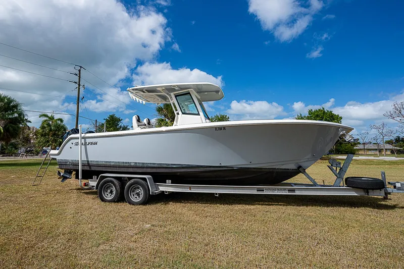 Slide: The Image of 2022 Sailfish 272CC boat on trailer under blue sky. - 2