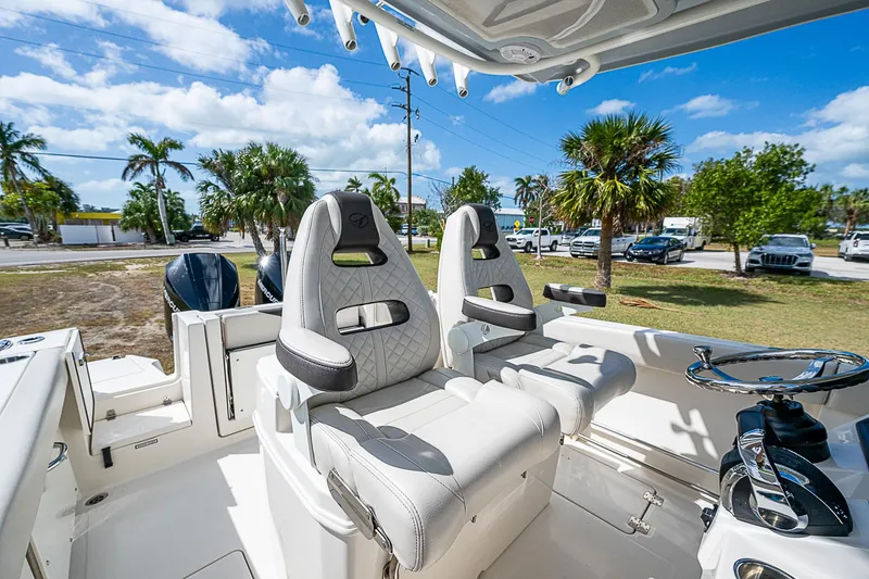 Slide: The Image of 2022 Sailfish 272CC boat interior with plush seating and steering wheel. - 20