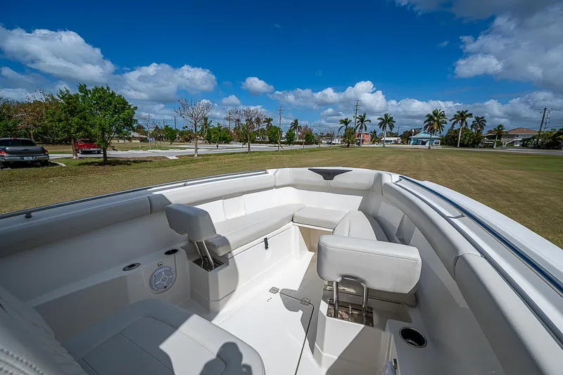 Slide: The Image of 2022 Sailfish 272CC boat interior with seating, under a clear blue sky. - 26