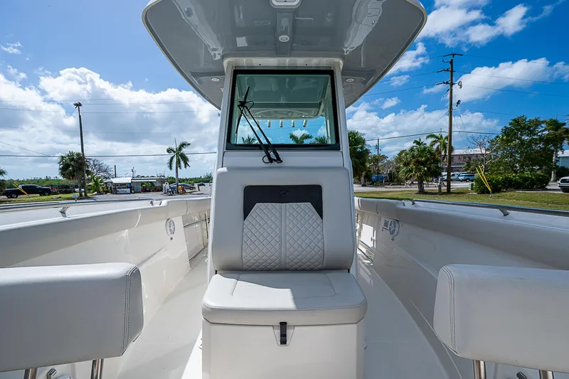 Slide: The Image of 2022 Sailfish 272CC boat interior with seating, clear skies, and palm trees in the background. - 33