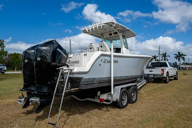 Slide: The Image of 2022 Sailfish 272CC boat on trailer, parked on grass under blue sky. - 4