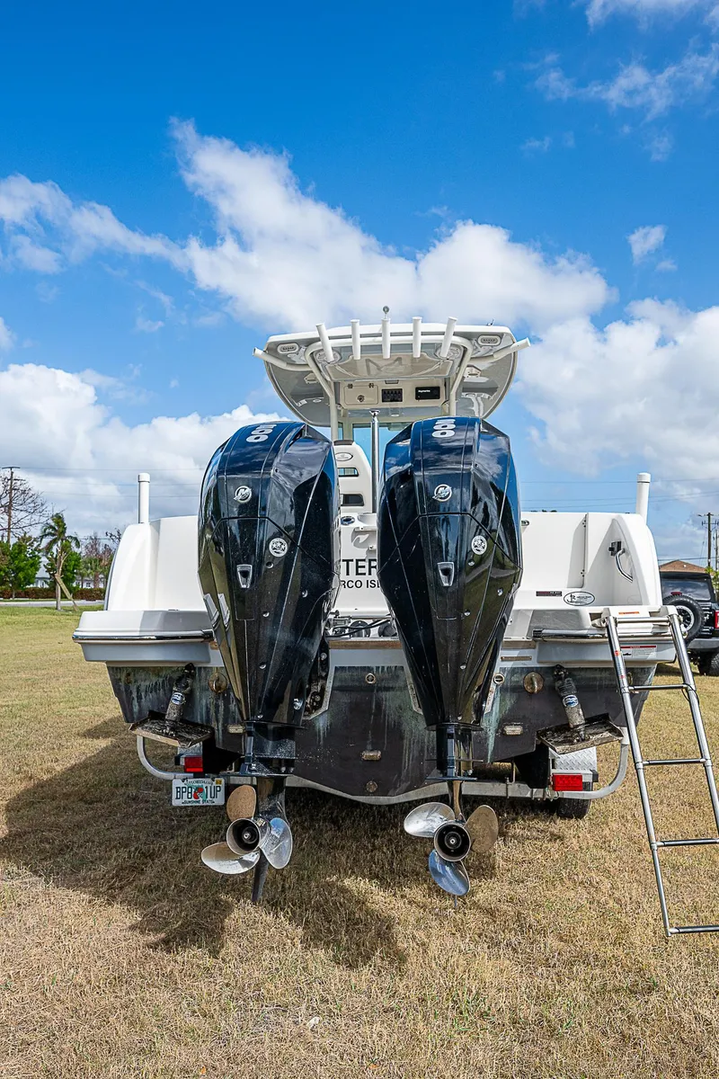 Slide: The Image of 2022 Sailfish 272CC boat with dual outboard motors on grassy field. - 5