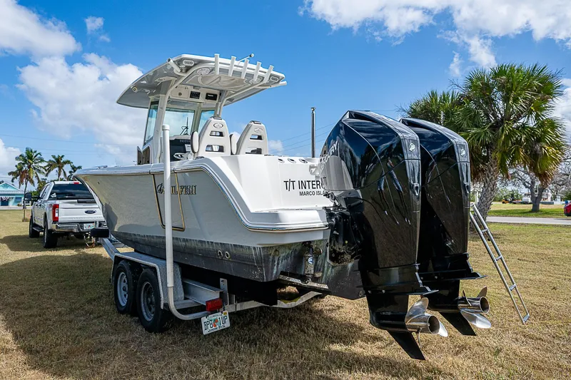 Slide: The Image of 2022 Sailfish 272CC boat on trailer with dual engines, parked on grass. - 6