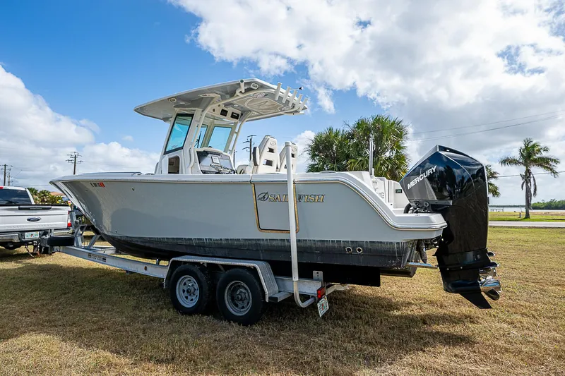 Slide: The Image of 2022 Sailfish 272CC boat on trailer, parked on grass under a partly cloudy sky. - 7
