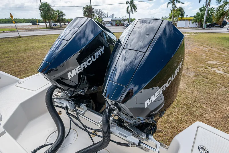 Slide: The Image of Twin Mercury outboard engines on 2022 Sailfish 272CC boat, parked on grass. - 9