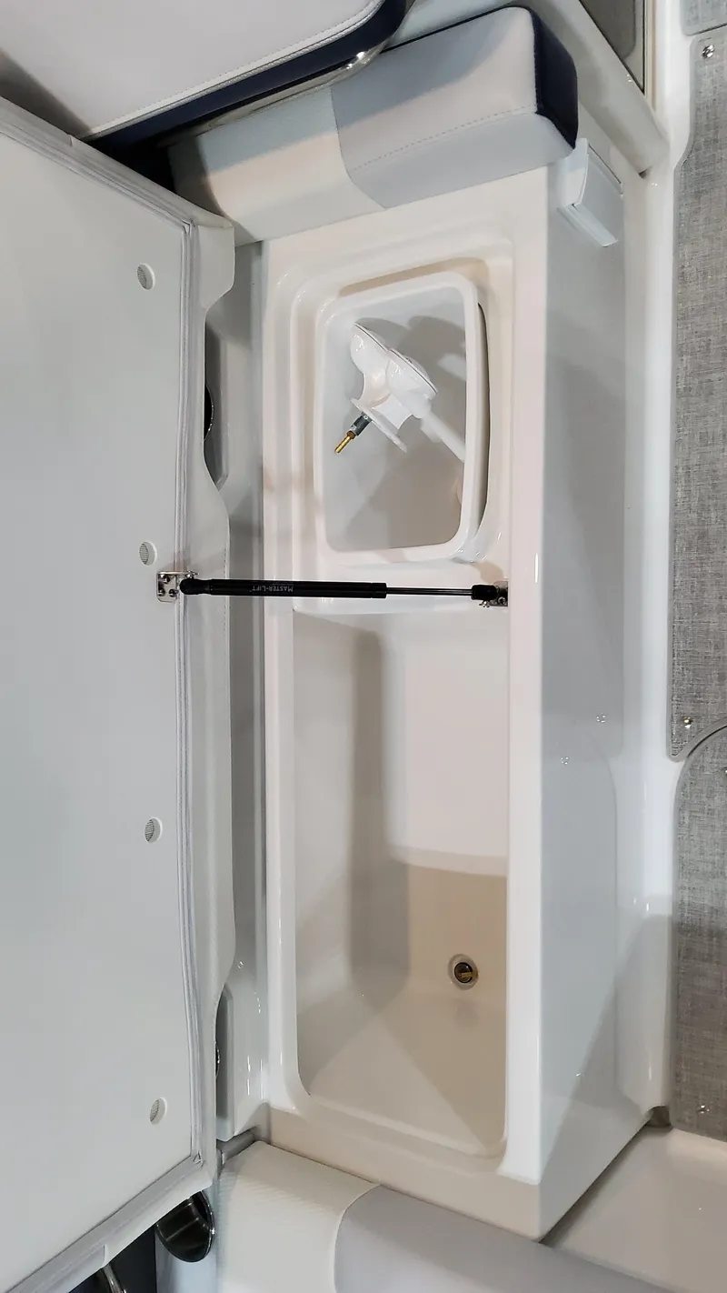 Slide: The Image of 2025 Formula 330 Crossover Bowrider I/O storage compartment with open lid. - 15