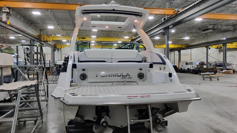 Slide: The Image of 2025 Formula 330 Crossover Bowrider I/O in a spacious indoor facility. - 2