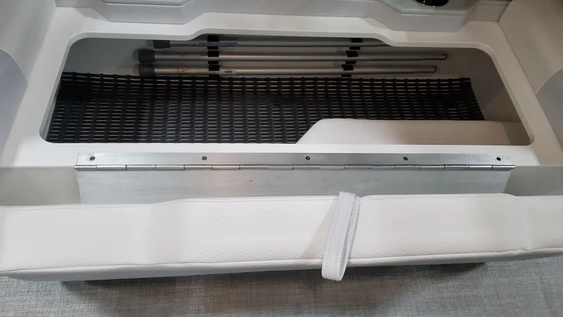 Slide: The Image of 2025 Formula 330 Crossover Bowrider I/O storage compartment with netting and white upholstery. - 21