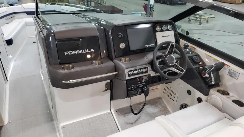 Slide: The Image of 2025 Formula 330 Crossover Bowrider I/O cockpit with modern controls and steering wheel. - 24