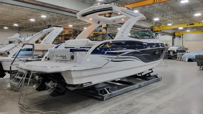 Slide: The Image of 2025 Formula 330 Crossover Bowrider I/O in a showroom, sleek design, luxury features. - 3