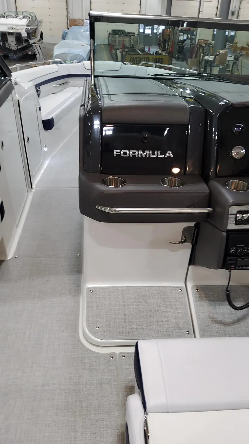 Slide: The Image of 2025 Formula 330 Crossover Bowrider I/O interior view, showcasing helm and seating area. - 40