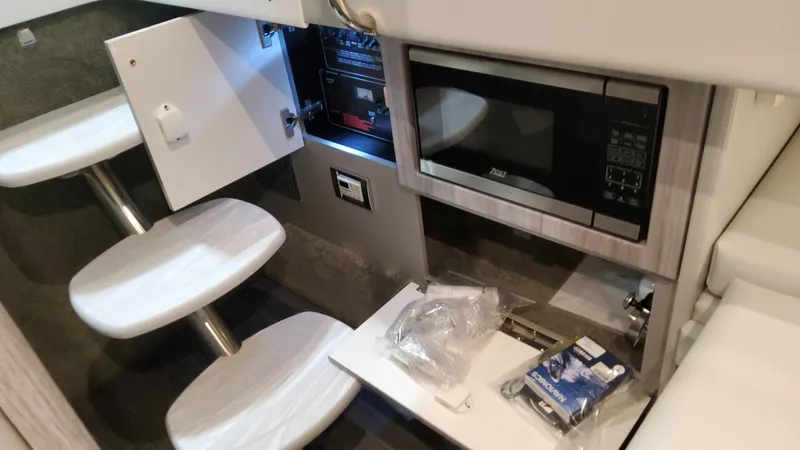 Slide: The Image of 2025 Formula 330 Crossover Bowrider I/O interior with microwave and storage compartments. - 49