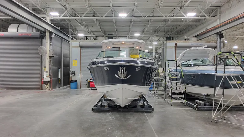 Slide: The Image of 2025 Formula 330 Crossover Bowrider I/O in a factory setting, front view. - 5